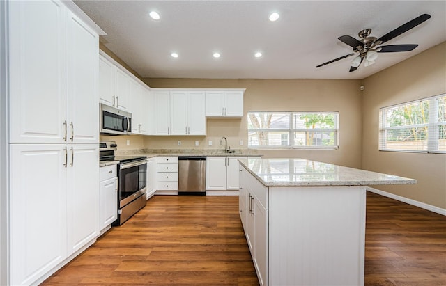 kitchen featuring appliances with stainless steel finishes, sink, white cabinets, and dark hardwood / wood-style flooring