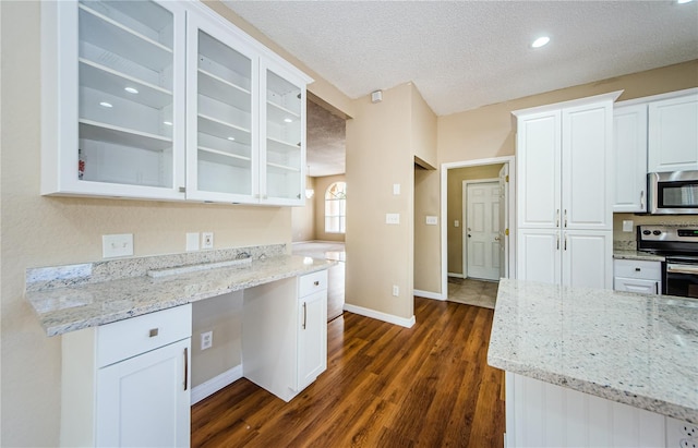 kitchen featuring light stone countertops, appliances with stainless steel finishes, and white cabinets