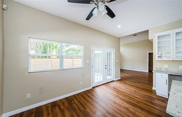 interior space featuring french doors, white cabinetry, dark hardwood / wood-style flooring, ceiling fan, and light stone countertops