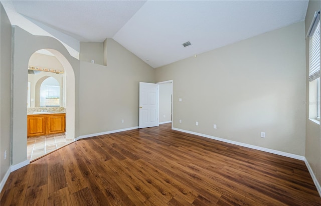 unfurnished room featuring lofted ceiling and dark hardwood / wood-style flooring