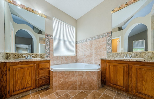 bathroom with a relaxing tiled tub and vanity