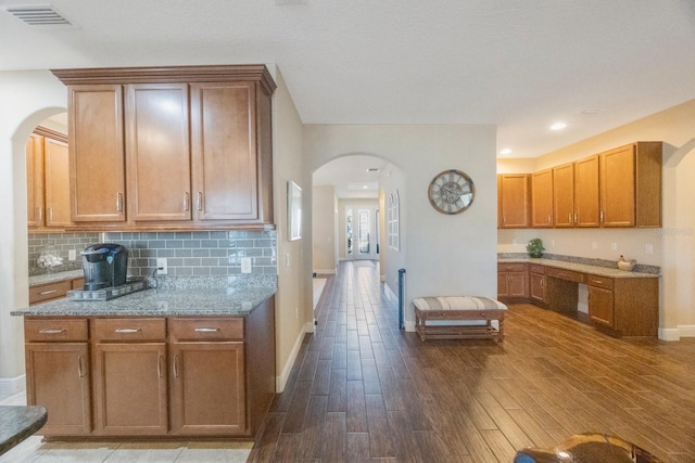 kitchen with light stone counters and backsplash