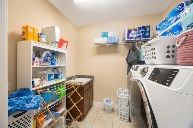 laundry area with cabinets, sink, light tile patterned floors, and independent washer and dryer