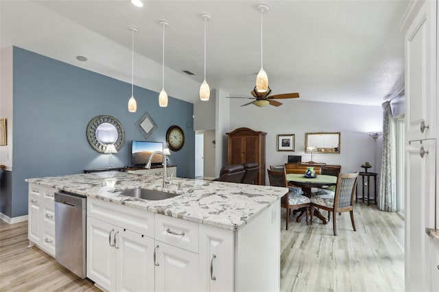 kitchen featuring white cabinetry, sink, stainless steel dishwasher, light stone countertops, and light wood-type flooring