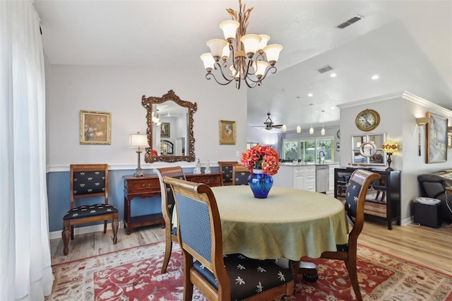 dining area featuring ceiling fan with notable chandelier and light hardwood / wood-style floors