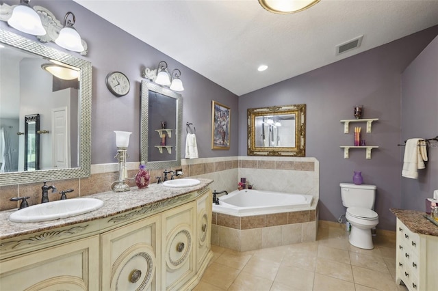 bathroom with lofted ceiling, tiled tub, tile patterned flooring, vanity, and toilet