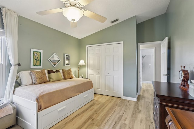 bedroom featuring vaulted ceiling, ceiling fan, light hardwood / wood-style floors, and a closet