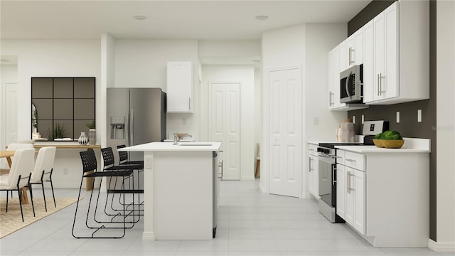 kitchen featuring sink, stainless steel appliances, a kitchen breakfast bar, white cabinets, and a center island with sink