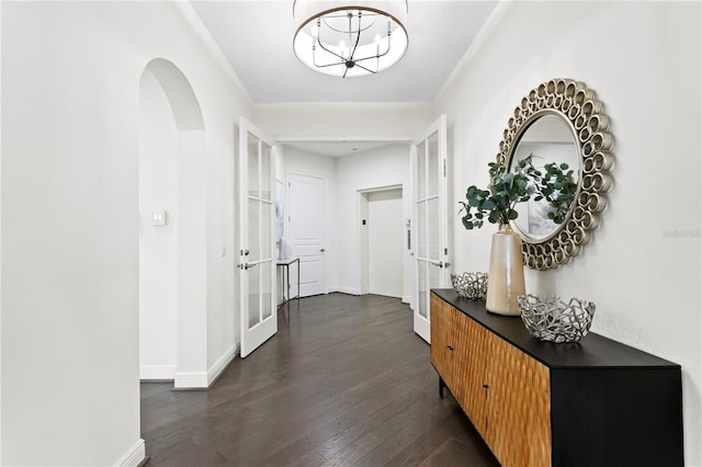 hallway with a notable chandelier, dark hardwood / wood-style flooring, and french doors