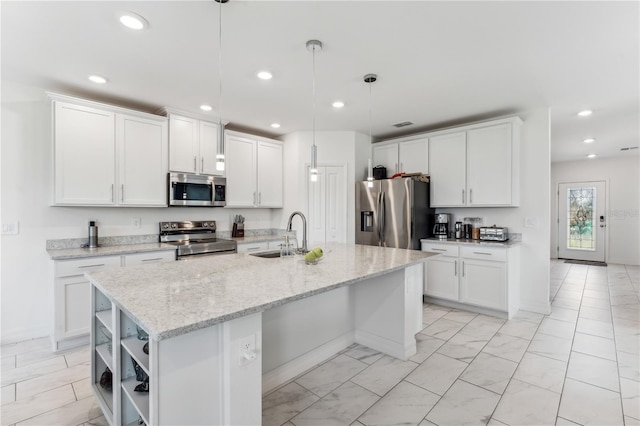 kitchen featuring white cabinetry, sink, decorative light fixtures, and appliances with stainless steel finishes