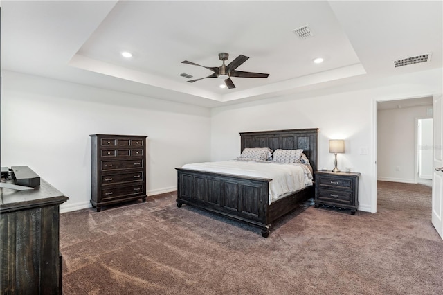 carpeted bedroom featuring a raised ceiling and ceiling fan