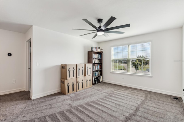 carpeted spare room with ceiling fan