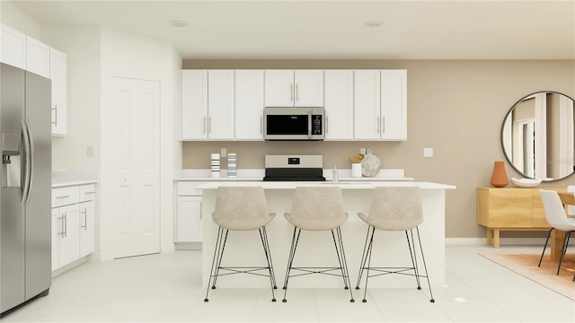 kitchen with white cabinetry, a kitchen bar, a center island with sink, and appliances with stainless steel finishes