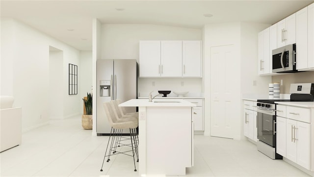 kitchen with stainless steel appliances, a breakfast bar area, a center island with sink, and white cabinets