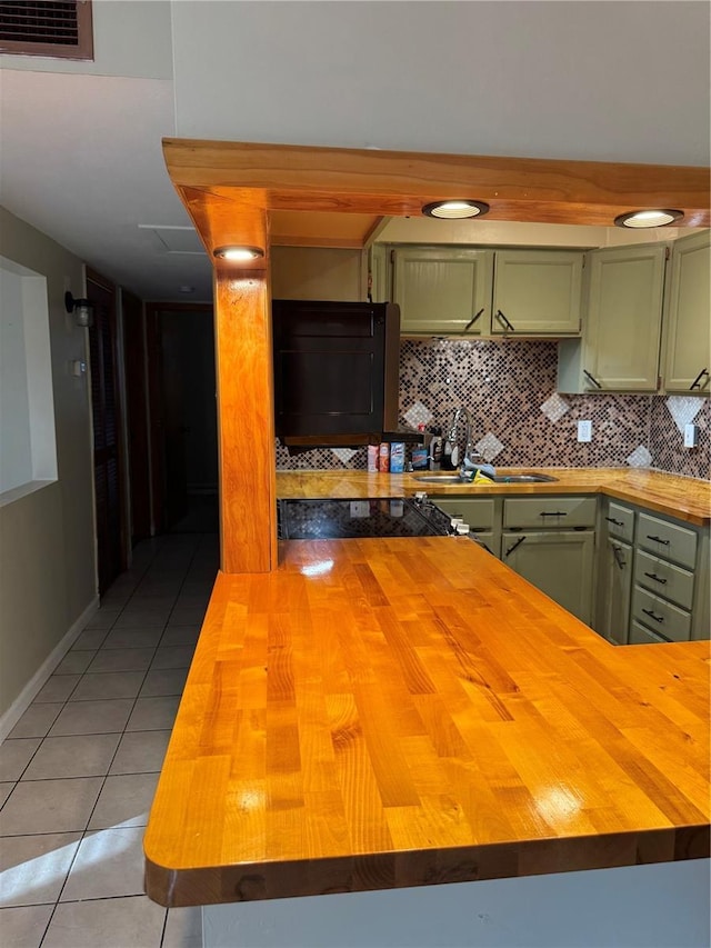 kitchen featuring butcher block counters, light tile patterned floors, and green cabinets