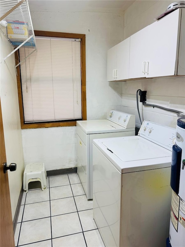 laundry area featuring cabinets, electric water heater, washer and dryer, and light tile patterned floors