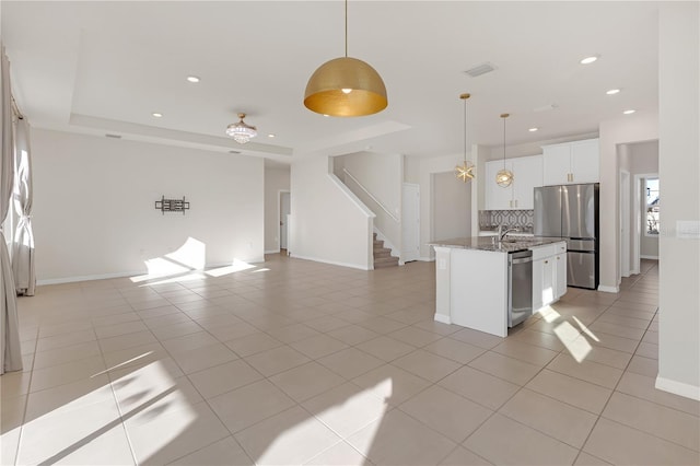 kitchen with white cabinetry, hanging light fixtures, light tile patterned floors, stainless steel appliances, and a center island with sink