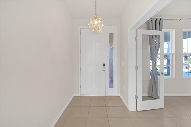 tiled foyer entrance with a chandelier