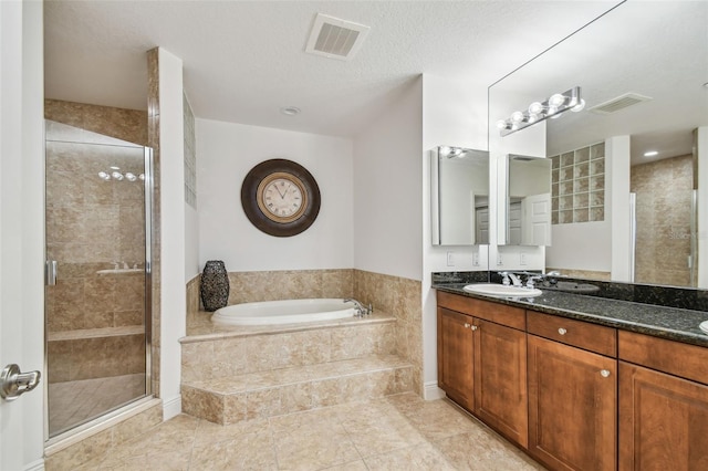 bathroom featuring vanity, separate shower and tub, and a textured ceiling