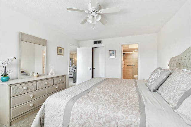 carpeted bedroom featuring ceiling fan, a textured ceiling, and ensuite bathroom