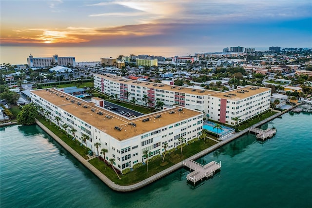 aerial view at dusk featuring a water view