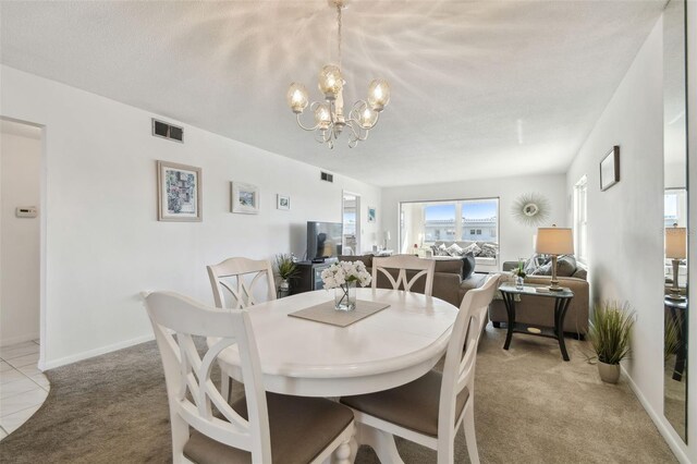 carpeted dining room with a notable chandelier