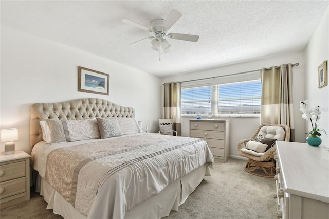 carpeted bedroom featuring ceiling fan and a textured ceiling