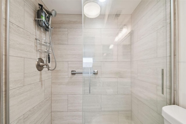 bathroom with an enclosed shower and toilet