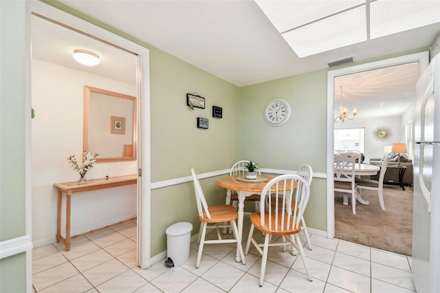 dining room featuring light tile patterned floors and a notable chandelier