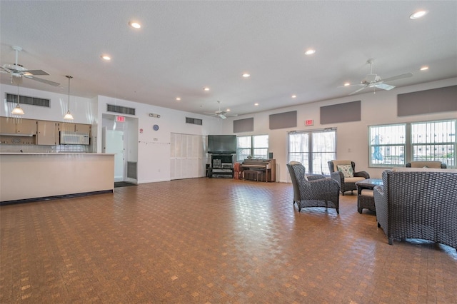 living room featuring a towering ceiling and ceiling fan