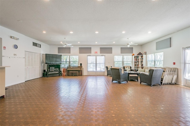 unfurnished living room with ceiling fan and a textured ceiling