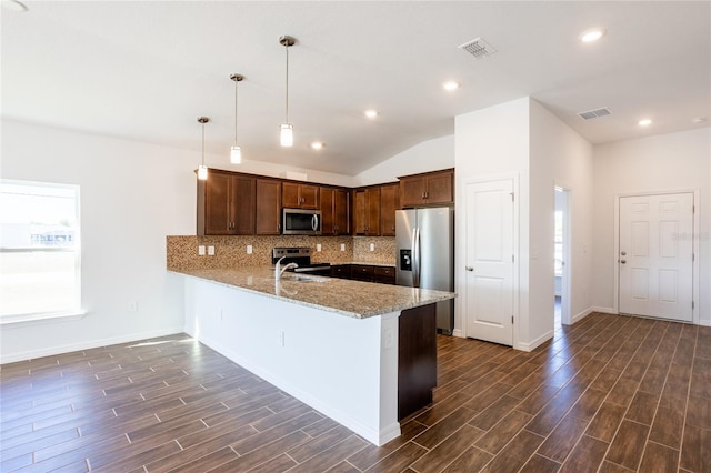 kitchen featuring appliances with stainless steel finishes, decorative light fixtures, tasteful backsplash, kitchen peninsula, and light stone countertops