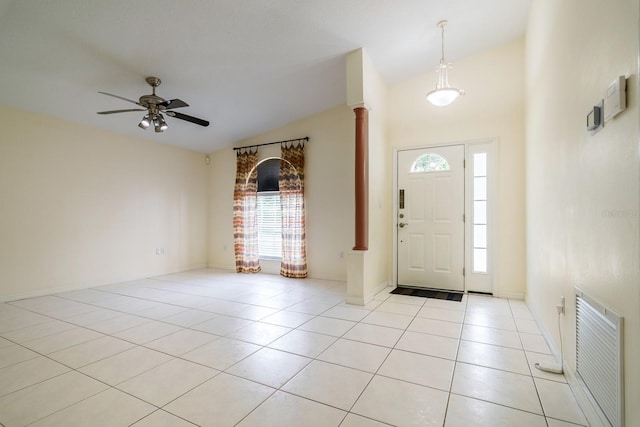 entryway with ornate columns, ceiling fan, vaulted ceiling, and light tile patterned floors