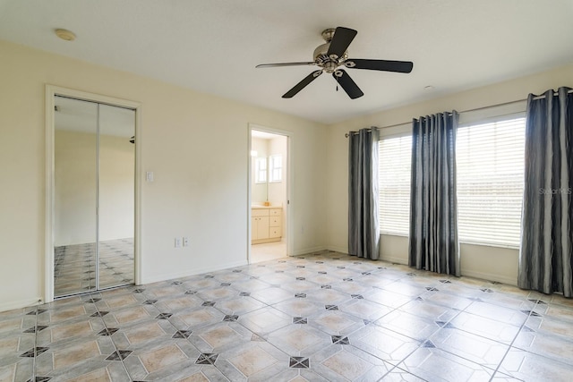 unfurnished bedroom featuring connected bathroom, ceiling fan, and a closet