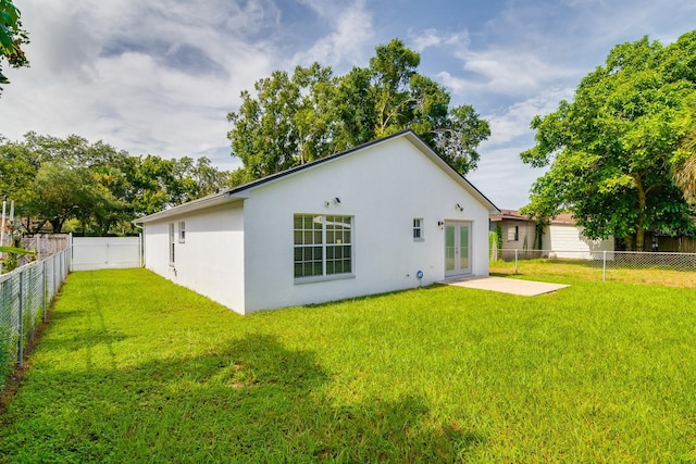 rear view of house featuring french doors, a yard, and a patio area