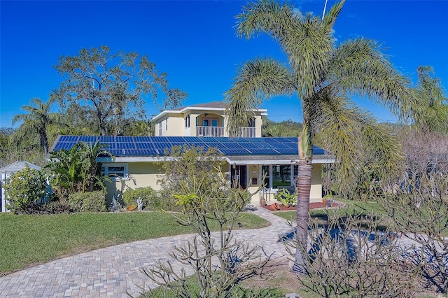 view of front of house with a front lawn and solar panels