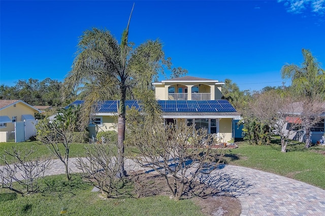 view of front facade featuring a front lawn and solar panels