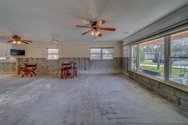 miscellaneous room with ceiling fan and a textured ceiling