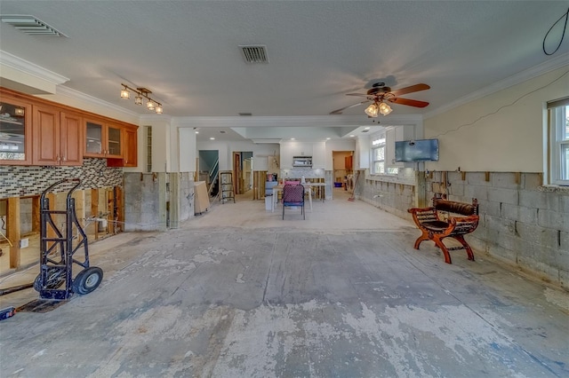 interior space featuring ornamental molding, a wealth of natural light, and ceiling fan