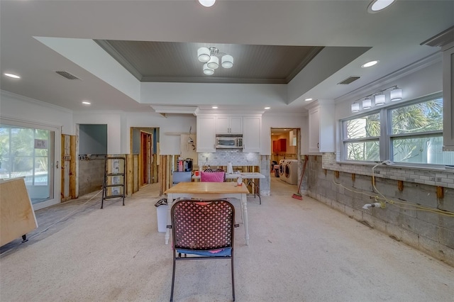 interior space featuring a raised ceiling, ornamental molding, and plenty of natural light