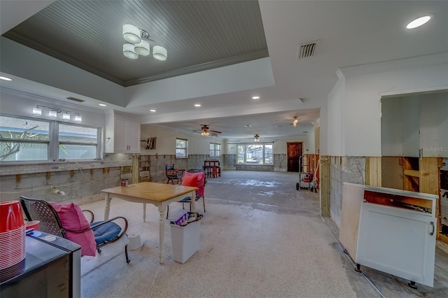 interior space with crown molding, ceiling fan, and a tray ceiling