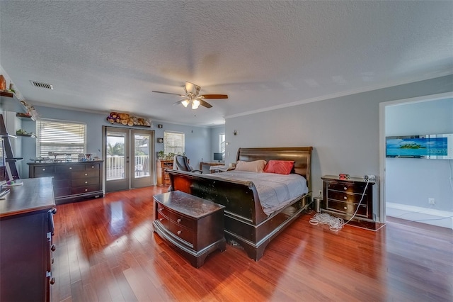 bedroom featuring dark hardwood / wood-style floors, access to outside, ornamental molding, and french doors