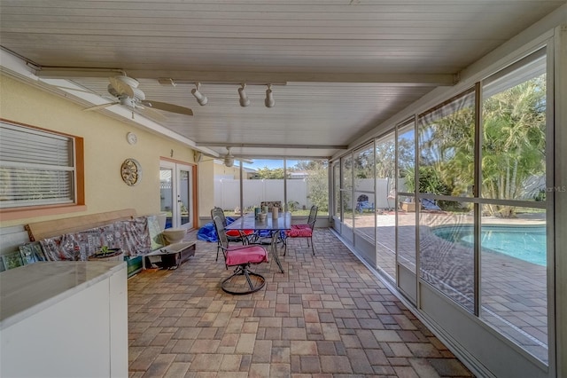 sunroom featuring rail lighting and ceiling fan