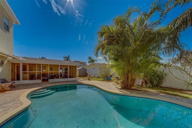 view of swimming pool with a patio and a sunroom