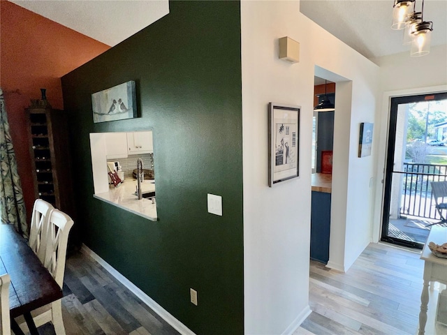 corridor featuring wood-type flooring and sink