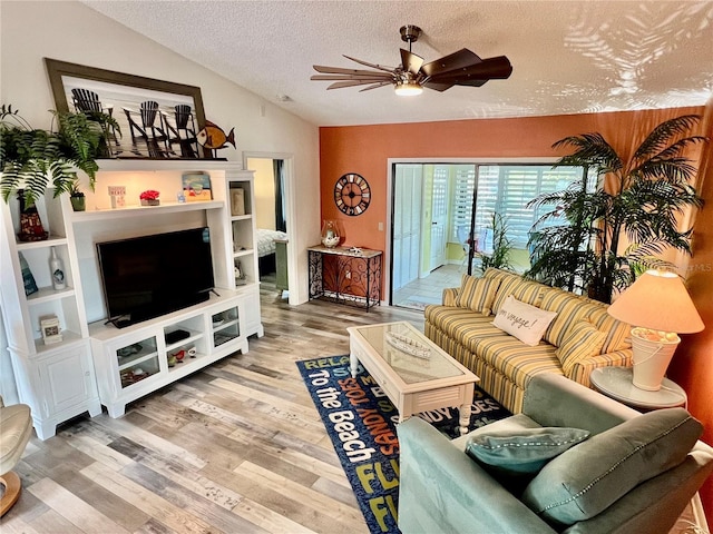 living room featuring lofted ceiling, hardwood / wood-style floors, a textured ceiling, and ceiling fan