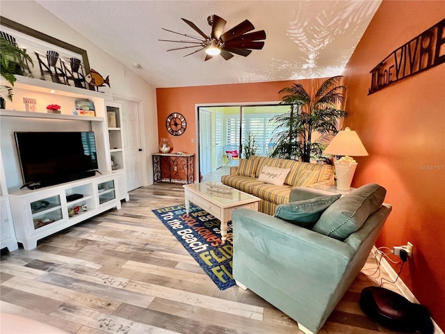 living room featuring ceiling fan, lofted ceiling, hardwood / wood-style floors, and a textured ceiling