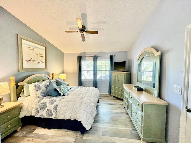 bedroom with multiple windows, vaulted ceiling, and light hardwood / wood-style flooring