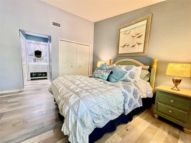 bedroom with light hardwood / wood-style floors and a closet