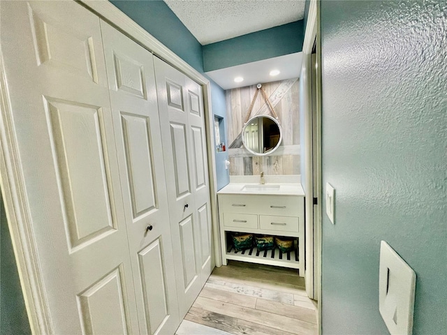 bathroom with vanity, hardwood / wood-style flooring, and a textured ceiling